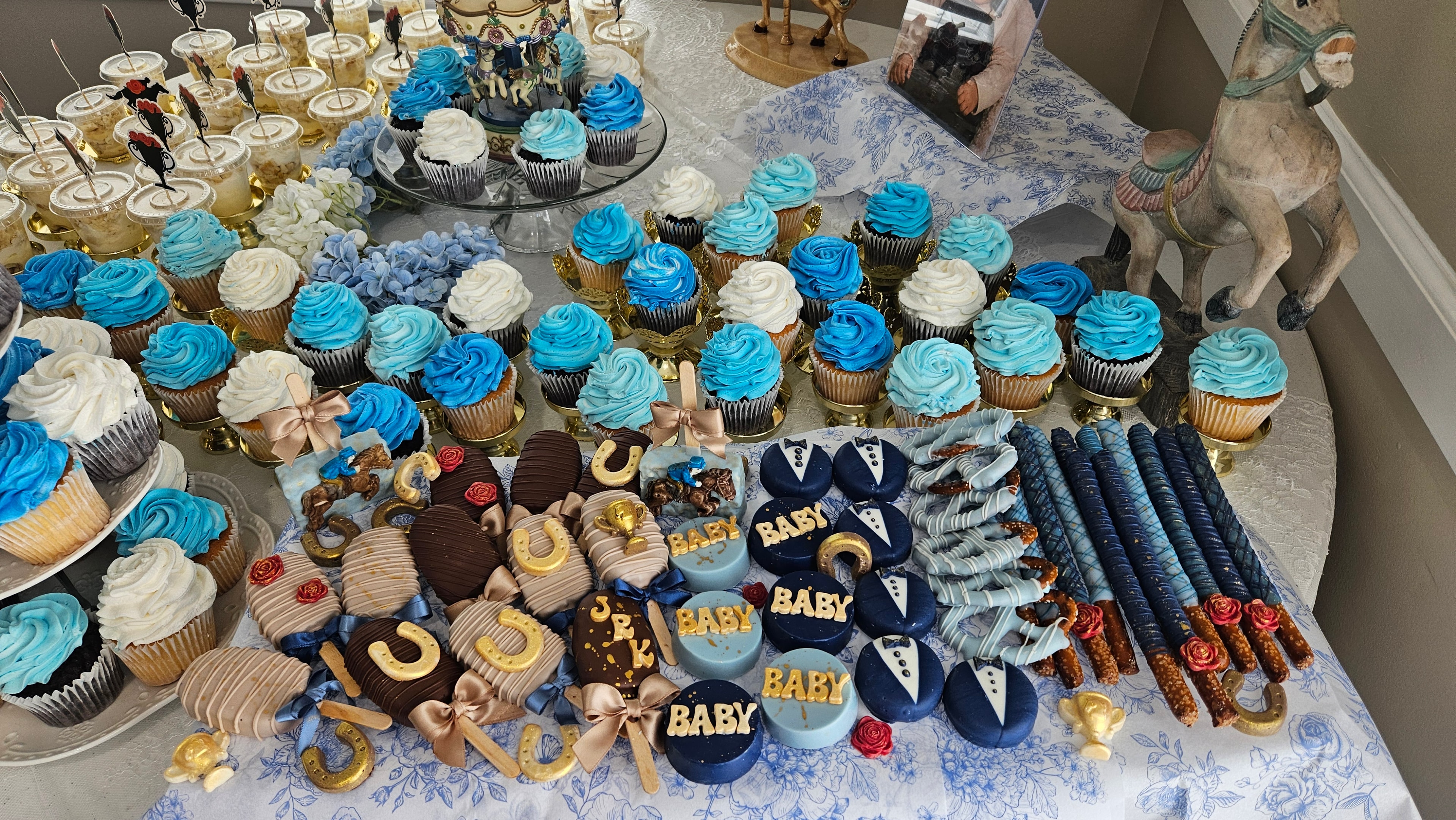 Baby shower dessert table with blue and gold treats